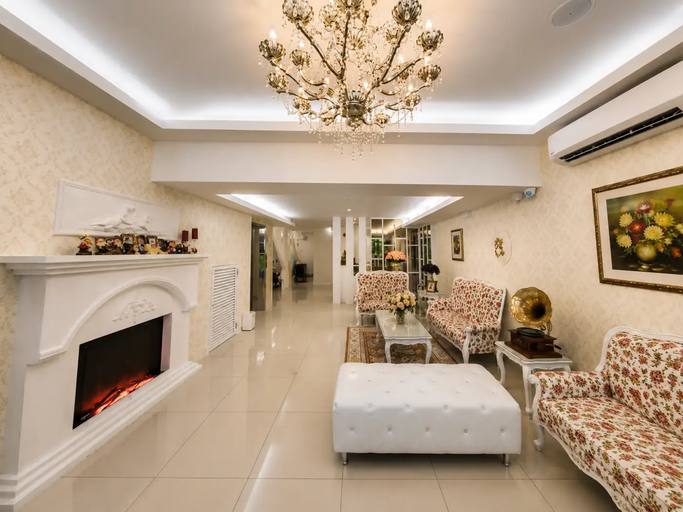 Ruang santai lobi 52 The Grace Hotel dengan candelier, perapian hiasan dan tempat duduk
